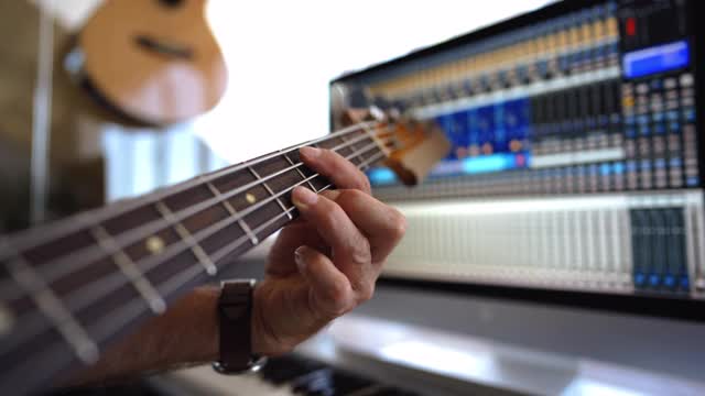 高级音乐家在音乐工作室弹奏低音吉他的特写视频素材