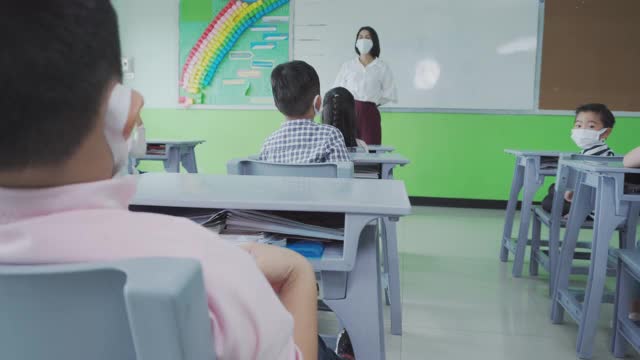 小学生在教室里戴着口罩。视频下载