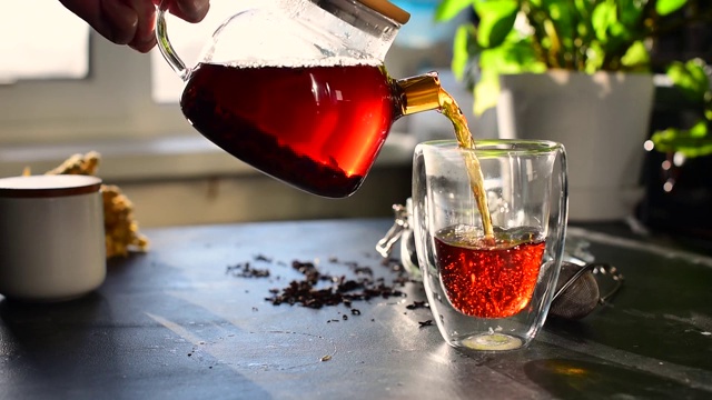 将泡好的绿茶从茶壶中倒入杯中。茶会、仪式和禅宗传统。一杯绿茶和一个茶壶。果片花茶。仪式上,传统的饮料。高质量的照片视频下载