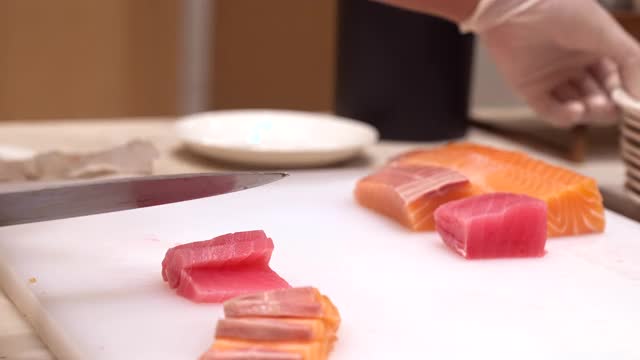 4K超高清慢动作手持:近距离厨师的手服务鲑鱼和金枪鱼生鱼片，日本美食。视频下载