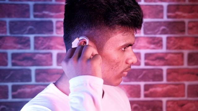 助听器概念，一个听力有问题的年轻人。视频素材