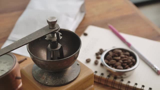 人们用手把烤好的咖啡豆倒入咖啡研磨机视频下载