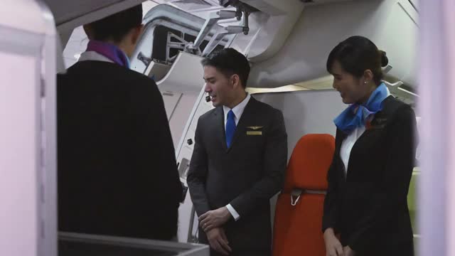 在飞机上，空姐和乘务员都穿制服，欢迎乘客。旅游、度假的概念。视频素材