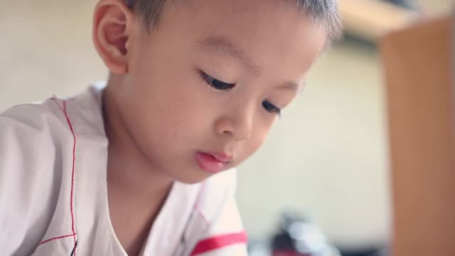 可爱的亚洲男孩玩玩具的意图。视频下载