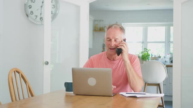 退休老人在家用笔记本电脑打电话视频素材