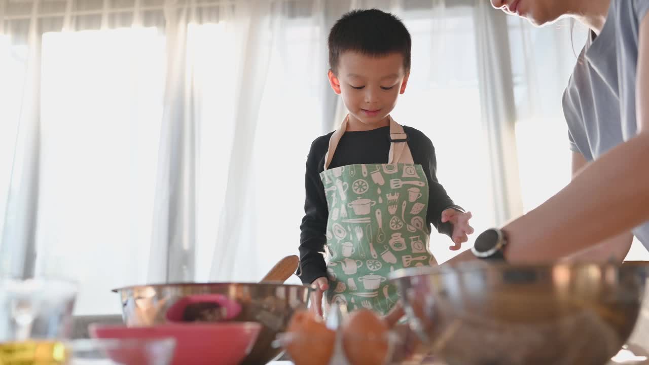 亚洲快乐可爱的男孩玩和烘培在家庭厨房有趣。自制食物和面包。教育与学习理念。泰国人视频下载
