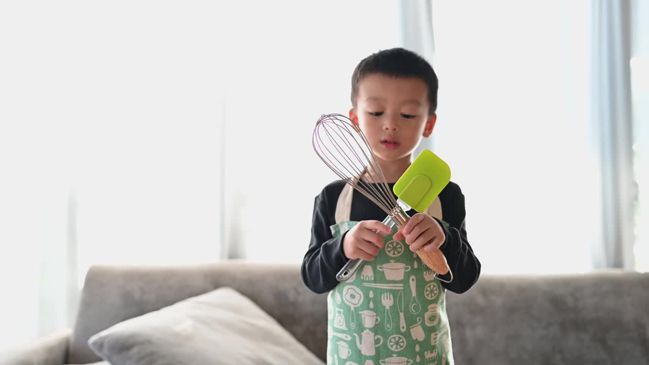 亚洲快乐可爱的男孩准备设备，帮助他的母亲做蛋糕。家庭活动的概念。视频下载
