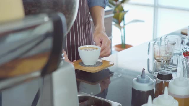 咖啡师在咖啡馆为顾客提供热饮料。视频素材