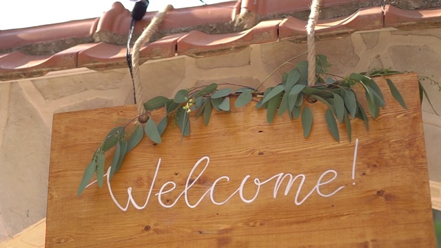 刻有“欢迎”字样的木桌，用桉树枝装饰视频素材