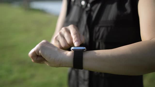 女性跑步者使用智能手表的特写视频下载