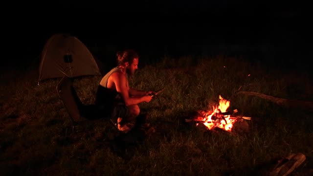 在户外露营的人给篝火添柴视频下载