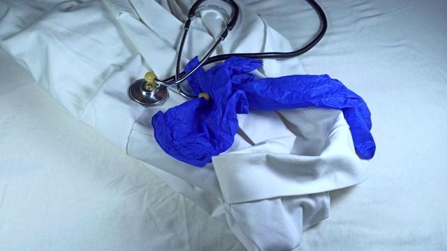 医生拿着医袍、听诊器和医用手套。冠状病毒大流行的危险。2019冠状病毒病研究与治疗。科学家们研究。卫生保健的概念。视频下载