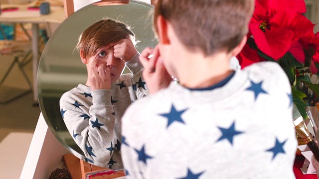 男孩在镜子里看着自己圆圆的眼睛，那是人体解剖学。视频素材