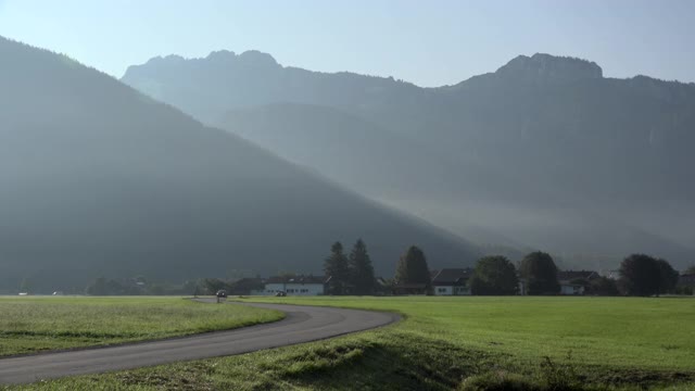 巴伐利亚阿尔卑斯山前乡间路上的汽车视频素材
