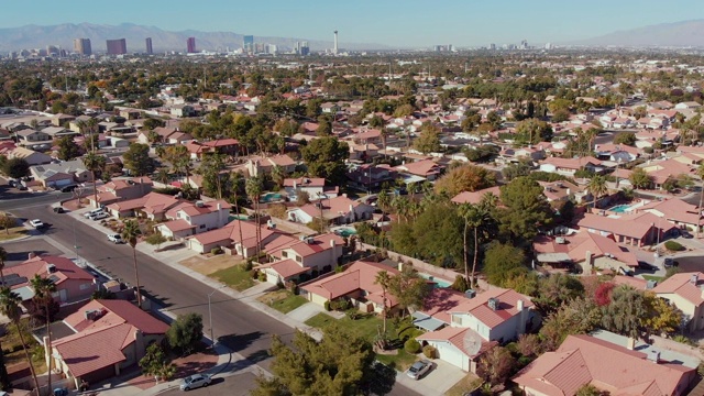 视频剪辑在拉斯维加斯，内华达州与春天山脉和拉斯维加斯天际线的背景在一个发展的小区的单一家庭住宅视频素材