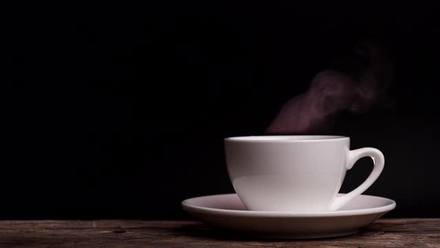 咖啡杯用天然蒸汽烟熏的咖啡在深色的背景与复制空间，慢动作。热咖啡饮品概念。视频素材
