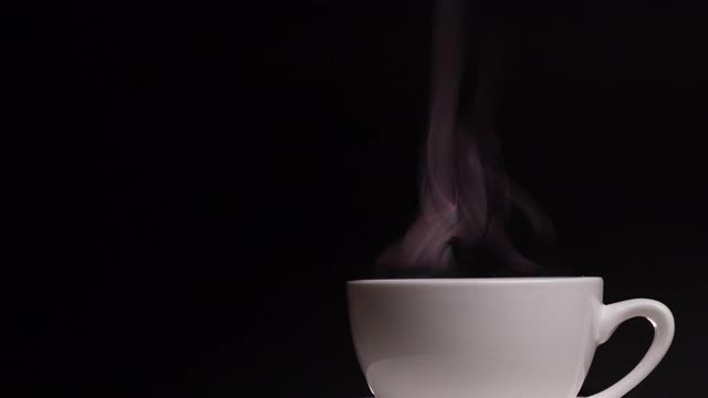 咖啡杯用天然蒸汽烟熏的咖啡在深色的背景与复制空间，慢动作。热咖啡饮品概念。视频素材