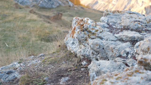 女人的双腿踩在山坡上的老石头上特写视频素材