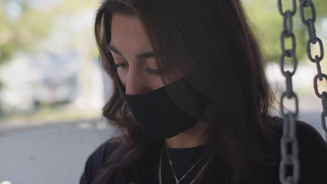 一名年轻女子戴着防护面具在门廊上写日记视频素材