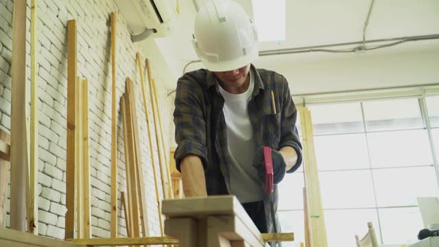 木匠正在用手锯锯木头视频素材