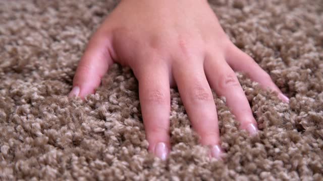近距离接触软地毯的手。手指间柔软蓬松的地毯视频下载