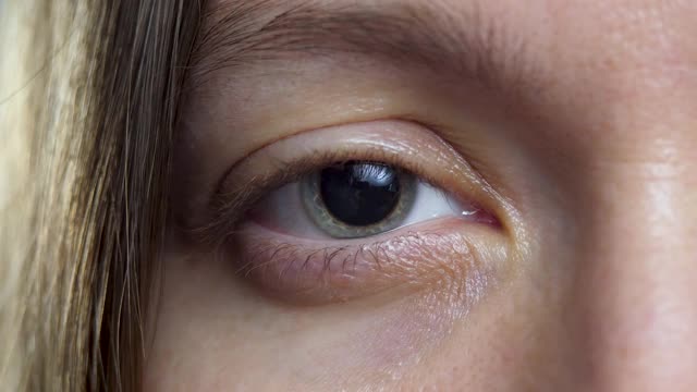 女性的眼睛，瞳孔周围有灰色和蓝色区域是虹膜视频素材