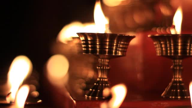 寺庙牛油灯节上的佛坛蜡烛视频。在金属容器中祈祷的油灯和摇曳的火焰，宁静的风景视频素材