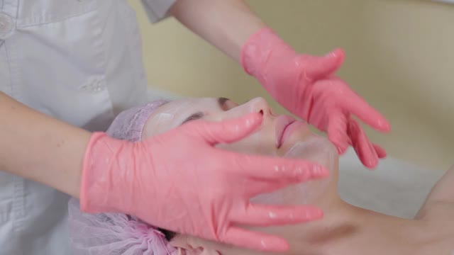 专业美容师在脸上涂抹液体霜视频下载