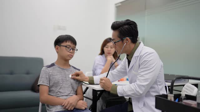 亚洲华人单身母亲带着孩子去看医生。医生用听诊器检查儿童心跳。视频素材