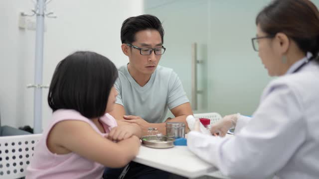 亚洲华人女医生开药并向病人的父亲解释。视频素材