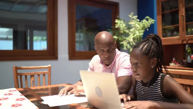 父亲帮助十几岁的女儿做作业视频素材