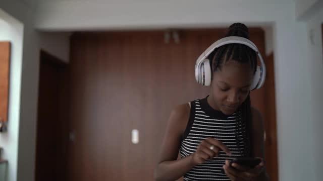 十几岁的女孩在家边听音乐边散步视频素材