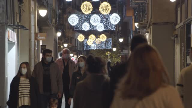2020年巴塞罗那圣诞新常态。covid-19危机期间戴口罩的街头人群视频下载