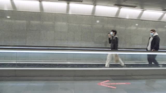 巴塞罗那地铁。新冠疫情危机期间佩戴口罩使用传送带的人成为新常态视频素材