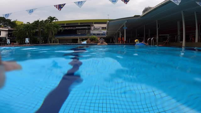 低角度视图亚洲华人男子游泳运动员游泳过游泳池视频素材