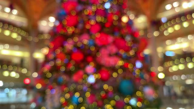 在美丽的购物中心里，一棵模糊的闪闪发光的圣诞树视频素材