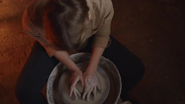 SLO MO年轻的女陶工在轮子上塑造粘土视频素材