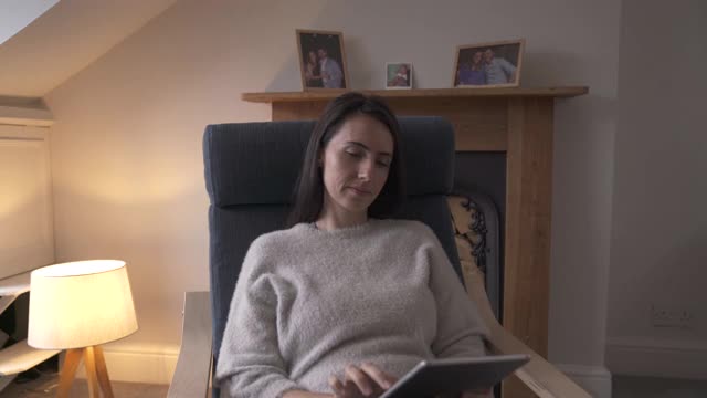 在家放松时使用平板电脑的女人视频下载