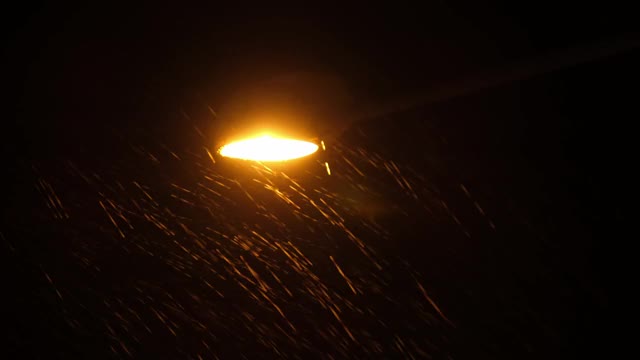 在暴风雨的日子里，雨滴在街灯的灯光下很明显。视频素材