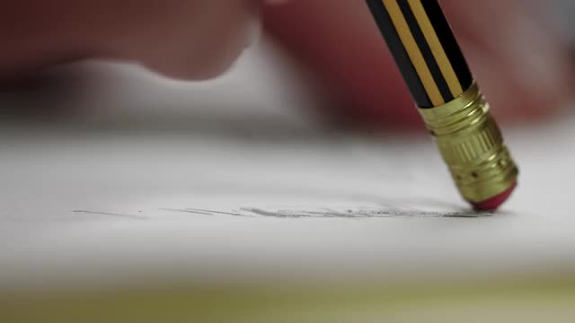 特写-一个男人的手用铅笔和橡皮擦擦什么是从一张纸上画。办公室或手工制品。视频下载