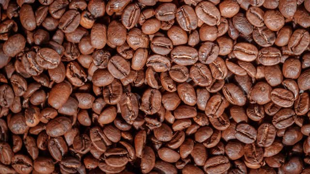 近距离观察咖啡种子。芳香的咖啡豆是由咖啡豆烘烤出来的烟熏出来的。视频下载
