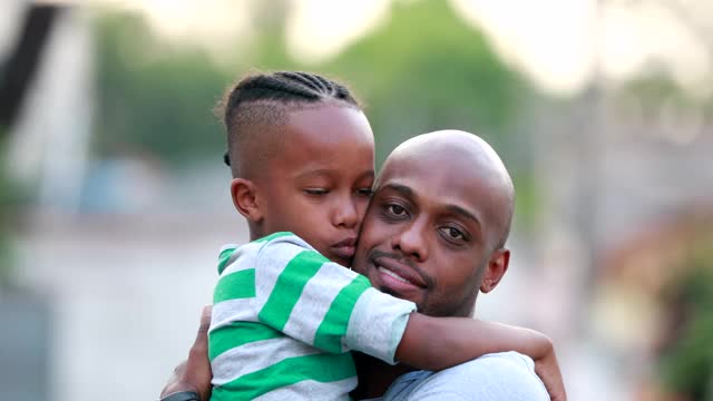 父亲和儿子的爱和亲情。非洲黑人的种族。爸爸和孩子拥抱视频下载