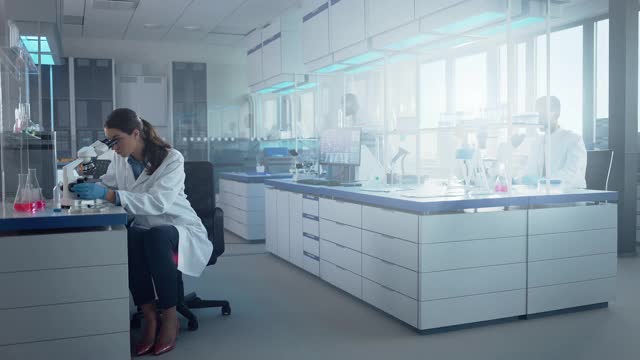 由生物化学科学家组成的医学实验室开发药物、药物、生物技术研究。使用计算机，使用显微镜，分析样品。移动拍摄视频素材