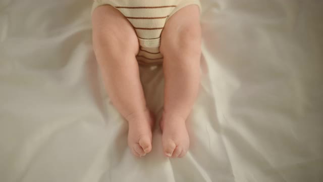 一个可爱的新生儿躺在婴儿床上的近距离滚动镜头。小小的白种人婴儿是水平的。童年、新生活和为人父母的概念。视频素材