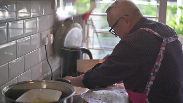 一名中国老人在厨房切鸡，为家人准备春节团圆饭视频素材