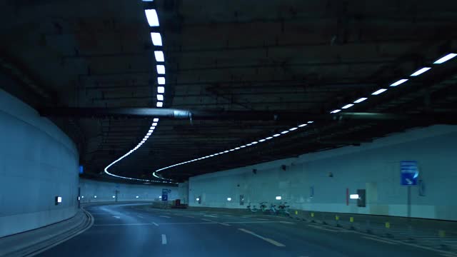 一辆车在夜间行驶在高速公路的隧道里视频下载