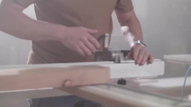 一个木匠在他的店铺里砍木头的特写视频素材