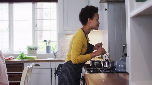 混血妇女在厨房做饭视频素材
