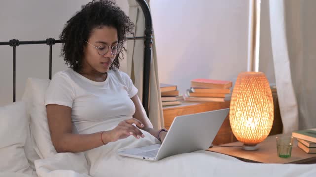 非洲妇女在床上丢失笔记本电脑视频素材