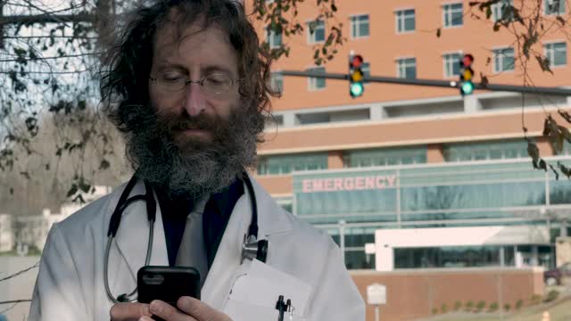 带着微笑的胡子站在外面的男医生视频下载
